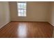 Empty bedroom featuring wood floors, neutral walls, and natural light from the window at 6600 121St Ave # 5, Largo, FL 33773