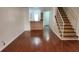 Open concept living room featuring hardwood floors, staircase, and view to the kitchen and entry door at 6600 121St Ave # 5, Largo, FL 33773