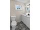 Bathroom featuring a toilet, stylish floors, black faucet and white vanity with modern lighting at 1849 New Hampshire Ne Ave, St Petersburg, FL 33703