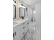 Renovated bathroom with double sinks, modern fixtures, quartz countertops, and marble tile flooring at 1849 New Hampshire Ne Ave, St Petersburg, FL 33703