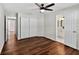 Open bedroom with hardwood floors, a ceiling fan, double closet doors, and an attached bathroom at 1849 New Hampshire Ne Ave, St Petersburg, FL 33703