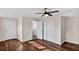 A bedroom with wood-look flooring, ceiling fan and closet, showing the entrance to an ensuite bathroom at 1849 New Hampshire Ne Ave, St Petersburg, FL 33703
