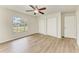 Spacious bedroom features light wood floors, ceiling fan, closet space, and a window overlooking the neighborhood at 221 Vermont E Ave, Bradenton, FL 34208