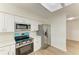 Modern kitchen featuring stainless steel appliances, white cabinetry, quartz countertops, and a skylight at 221 Vermont E Ave, Bradenton, FL 34208