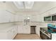 Modern kitchen with stainless steel appliances, white cabinets, quartz countertops, and lots of natural light at 221 Vermont E Ave, Bradenton, FL 34208