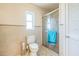 A cozy bathroom with tiled walls, a glass door shower, and a convenient linen closet at 2521 Carlisle Pl, Sarasota, FL 34231