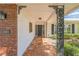 Home's front porch features decorative metal columns, brick accents, and tiled flooring at 2521 Carlisle Pl, Sarasota, FL 34231