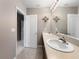 Bathroom showcasing double sinks with dark vanity and an adjacent doorway at 26835 Juniper Bay Dr, Wesley Chapel, FL 33544