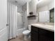 Bathroom featuring a shower/tub combo with white tiling, dark vanity, and an above-counter shelf at 26835 Juniper Bay Dr, Wesley Chapel, FL 33544
