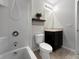 Bathroom featuring a shower/tub combo with white tiling, dark vanity, and light fixtures at 26835 Juniper Bay Dr, Wesley Chapel, FL 33544