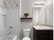 Bathroom showcasing a shower/tub combo with dark vanity, an above-counter shelf, and light fixtures at 26835 Juniper Bay Dr, Wesley Chapel, FL 33544