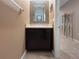 Bathroom vanity with dark wood cabinet and decorative mirror, leading to another room at 26835 Juniper Bay Dr, Wesley Chapel, FL 33544
