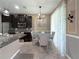 Dining area with modern chandelier adjacent to the kitchen with decorative wainscotting at 26835 Juniper Bay Dr, Wesley Chapel, FL 33544