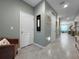 Hallway with neutral paint, tiled floors, and multiple doorways at 26835 Juniper Bay Dr, Wesley Chapel, FL 33544