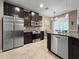 Stylish kitchen with stainless steel appliances, granite countertops, and dark cabinetry overlooking the dining area at 26835 Juniper Bay Dr, Wesley Chapel, FL 33544