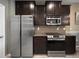 Modern kitchen featuring stainless steel appliances, granite countertops, and dark wood cabinetry at 26835 Juniper Bay Dr, Wesley Chapel, FL 33544