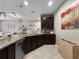 Spacious kitchen featuring a large island with granite countertops, dark cabinetry, and pendant lighting at 26835 Juniper Bay Dr, Wesley Chapel, FL 33544