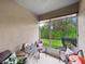 Relaxing enclosed lanai perfect for outdoor dining with views of the lush, green backyard at 26835 Juniper Bay Dr, Wesley Chapel, FL 33544