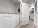 Convenient laundry room with washer, dryer, wire shelving, and easy access to the hallway at 26835 Juniper Bay Dr, Wesley Chapel, FL 33544