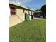 Backyard area features a grass lawn, covered patio, and exterior of the home at 13725 Plumosa Ave, Hudson, FL 34667