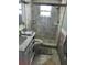 Bathroom featuring marble tiling, glass enclosed shower, and white vanity with sink at 13725 Plumosa Ave, Hudson, FL 34667