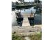 Wooden dock with a small seating area extends into the calm canal waters at 13725 Plumosa Ave, Hudson, FL 34667