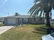 Charming single-story home with a well-maintained lawn and mature palm trees enhancing its curb appeal at 13725 Plumosa Ave, Hudson, FL 34667