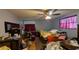A bedroom with a ceiling fan, windows, and hardwood floors, but currently untidy and cluttered at 249 Malvern Dr, Venice, FL 34293