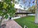View of the large, grassy backyard, a brick patio, and the deck running the length of the home at 4713 9Th E St, Ellenton, FL 34222