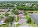 An aerial view showing lakeside homes, green lawns, mature trees, and lush landscaping at 9246 Dayflower Dr, Tampa, FL 33647