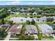Aerial view showcases a lakefront property with a manicured lawn and mature landscaping at 9246 Dayflower Dr, Tampa, FL 33647