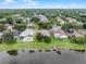 Aerial view of a waterfront property with mature trees, pool, and well-manicured lawns at 9246 Dayflower Dr, Tampa, FL 33647