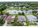 An aerial view of homes with well-manicured lawns situated next to a lake in a residential community at 9246 Dayflower Dr, Tampa, FL 33647