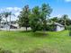 Spacious backyard features mature trees, lush green grass, and a view of neighboring homes at 9246 Dayflower Dr, Tampa, FL 33647