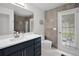 Well-lit bathroom features a navy vanity, modern fixtures, and tiled walls, combining style and functionality at 9246 Dayflower Dr, Tampa, FL 33647