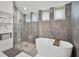 Modern bathroom with a soaking tub, glass shower, and gray tile at 9246 Dayflower Dr, Tampa, FL 33647