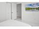 Bedroom with white interior and a TV mounted on the wall, offering a modern and clean aesthetic at 9246 Dayflower Dr, Tampa, FL 33647