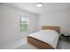 Bright bedroom with minimalist design, natural light from the window, and simple, modern furnishings at 9246 Dayflower Dr, Tampa, FL 33647