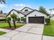 Inviting one-story home featuring a well-kept lawn, a two-car garage, and neatly trimmed landscaping at 9246 Dayflower Dr, Tampa, FL 33647