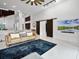 Spacious living room with white floors, a leather sofa, and a sliding barn door at 9246 Dayflower Dr, Tampa, FL 33647