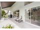 Covered patio with outdoor seating, barbecue grill, and sliding glass doors to the home's interior at 9246 Dayflower Dr, Tampa, FL 33647