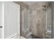 Modern shower featuring sleek glass enclosure, gray tile, and a rainfall showerhead for a spa-like experience at 9246 Dayflower Dr, Tampa, FL 33647