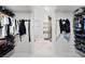 Walk-in closet with custom shelving and hanging space, leading to the bathroom at 9246 Dayflower Dr, Tampa, FL 33647