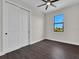 This bedroom features wood-look tile, a modern ceiling fan, and a window view at 9573 Migue Cir, Port Charlotte, FL 33981
