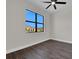 This bedroom features wood-look tile, a modern ceiling fan, and a large window at 9573 Migue Cir, Port Charlotte, FL 33981