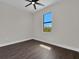 This bedroom features wood-look tile, a modern ceiling fan, and a bright window at 9573 Migue Cir, Port Charlotte, FL 33981