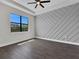 Bedroom with a tray ceiling, statement wall, and natural light at 9573 Migue Cir, Port Charlotte, FL 33981