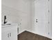This laundry room features a modern sink, crisp white paint, and wood-look tile at 9573 Migue Cir, Port Charlotte, FL 33981