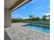 Inviting backyard pool with a stone paver deck and secure black metal fence at 9573 Migue Cir, Port Charlotte, FL 33981