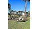 Charming home exterior featuring a lush, landscaped front yard with palm trees and vibrant plants at 134 Gulfview Rd, Punta Gorda, FL 33950